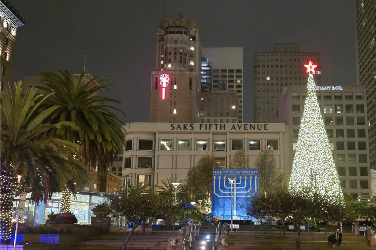 A Christmas tree is lit up beside a 25-foot-tall menorah in Union Square on Saturday, Dec. 21, 2024. The menorah will be lit from Dec. 25, 2024, to Jan. 2, 2025. (Christopher Roberts / Golden Gate Xpress)